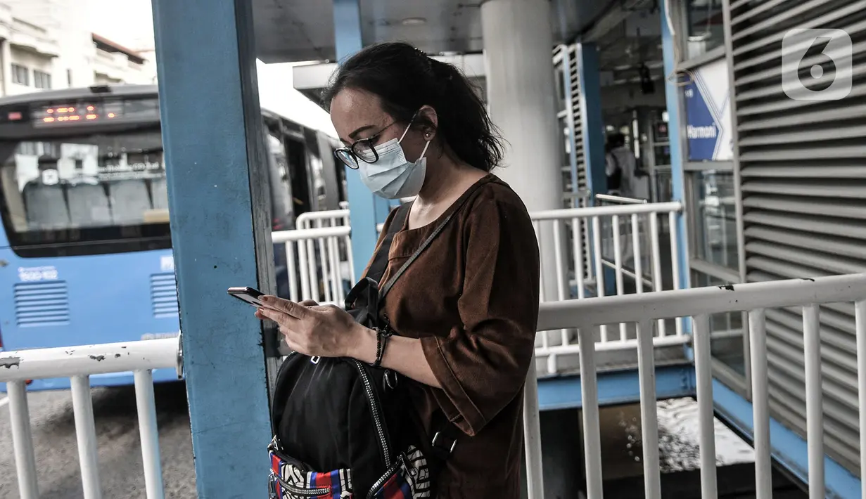 Calon penumpang mengoperasikan telepon genggam di Halte Harmoni, Jakarta, Senin (16/11/2020). Penyediaan fasilitas wifi gratis dilakukan di halte-halte tujuh koridor jaringan bus terintegrasi. (merdeka.com/Iqbal S. Nugroho)