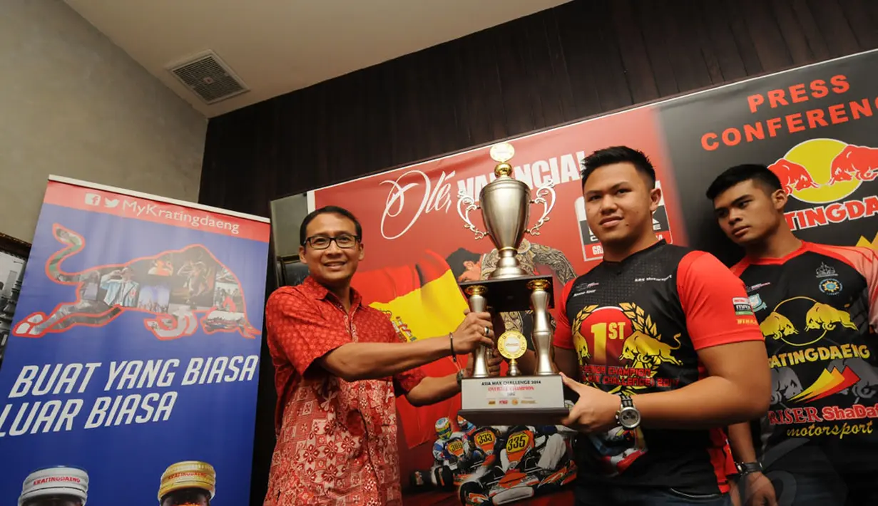 Pegokart Indonesia dari tim Kratingdaeng Riser ShaDaff Motorsport, Senna Noor (tengah) secara simbolis menyerahkan piala di ajang kejuaraaan dunia Rotax Max Challenge pada salah satu perwakilan sponsor, Jakarta (20/11). (Liputan6.com/Helmi Fithriansyah)