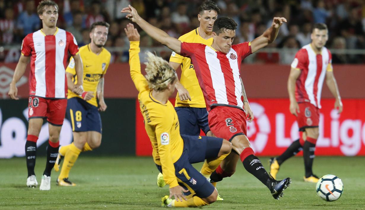 Aksi pemain Atletico Madrid,  Antoine Griezmann (kiri) menjegal pemain Girona, Bernando Espinosa pada La Liga Spanyol di Montilivi stadium, Girona (19/8/2017). Atletico bermain imbang 2-2. (AFP/Pau Barrena)
