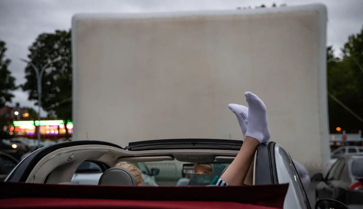 Seorang penonton menikmati film di sebuah bioskop drive-in yang digelar oleh warga Saint-Thibault-des-Vignes, suatu wilayah di pinggiran Kota Paris, Prancis, pada 4 Juli 2020. Bioskop berkonsep drive-in semakin populer di Prancis selama pandemi COVID-19. (Xinhua/Aurelien Morissard)