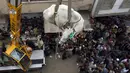 Pedagang menurunkan sapi dengan derek dari atap bangunan untuk dijual di pasar kurban sementara di Karachi, Minggu (12/8). Umat Islam di seluruh dunia akan merayakan Hari Raya Idul Adha yang identik dengan tradisi berkurban. (AP/Fareed Khan)