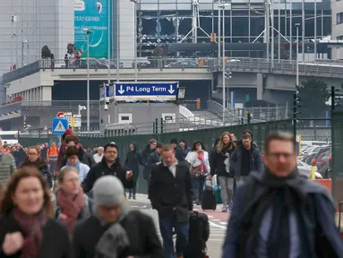 Sejumlah orang berjalan meninggalkan lokasi ledakan di bandara Zaventem dekat Brussels, Belgia, (22/3).Selain terjadi ledakan di Bandara, ledakan juga menghancurkan stasiun metro Maalbeek Brussels. (REUTERS / Francois Lenoir)