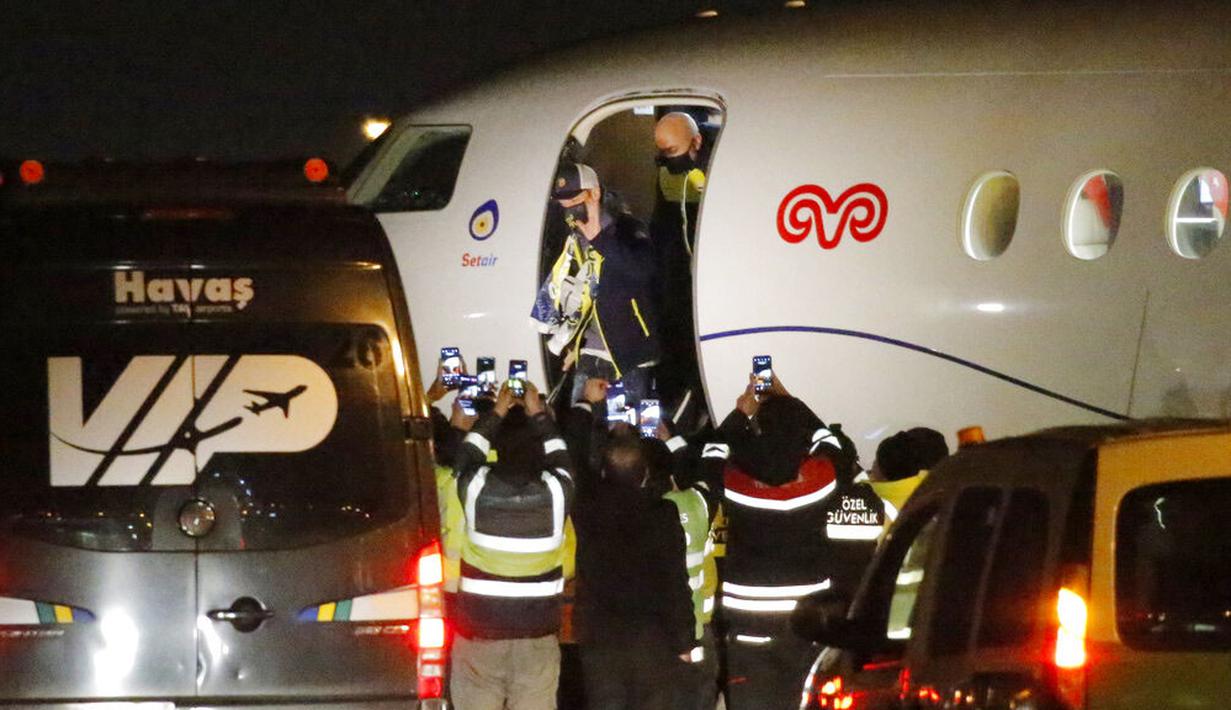 Pesepak bola asal Jerman, Mesut Ozil, turun dari pesawat saat tiba di Bandara Ataturk, Turki, Senin (18/1/2021). Setelah memutuskan hengkang dari Arsenal, Ozil akan memperkuat klub asal Turki, Fenerbahce. (AP Photo)
