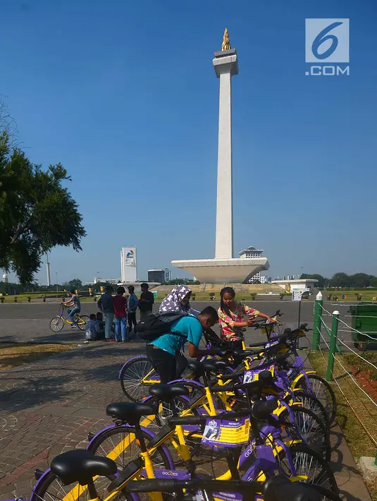 Pengunjung menscan QR Code untuk bisa menggunakan sepeda dari layanan bike sharing di Monas, Jakarta, Jumat (27/7). Cukup mengunduh aplikasi GOWES di Play Store atau App Store untuk dapat menggunakan layanan bike sharing. (Merdeka.com/Imam Buhori)