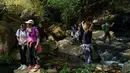 Orang-orang beristirahat di jalur pendakian dekat air terjun di Tseung Kwan O, Hong Kong, 1 Maret 2020. Warga Hong Kong memilih pergi ke daerah gunung dan jalur hiking dibandingkan harus tinggal di pusat kota yang sempit dan dibayangi ketakutan akan wabah virus corona (Covid-19). (VIVEK PRAKASH/AFP)