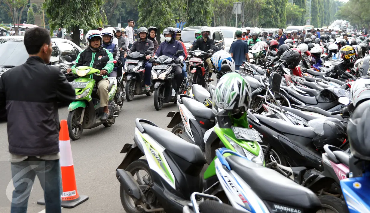 Pengendara antre melintasi Jalan Tegar Beriman Kab Bogor, Selasa (13/12). Ribuan calon suporter Timnas Indonesia antre membeli tiket laga final pertama di halaman Kodim 0621 Surya Kancana. (Liputan6.com/Helmi Fithriansyah)