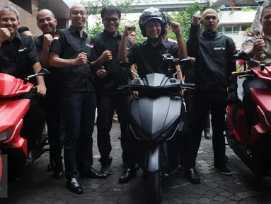 Menristekdikti Mohammad Nasir berpose di atas Motor listrik bernama Garansindo Electric Scooter ITS (GESITS) di Jakarta, Senin (7/11). GESITS adalah hasil kerjasama Garansindo dengan Institut Teknologi Sepuluh November (ITS). (Liputan6.com/Helmi Afandi)