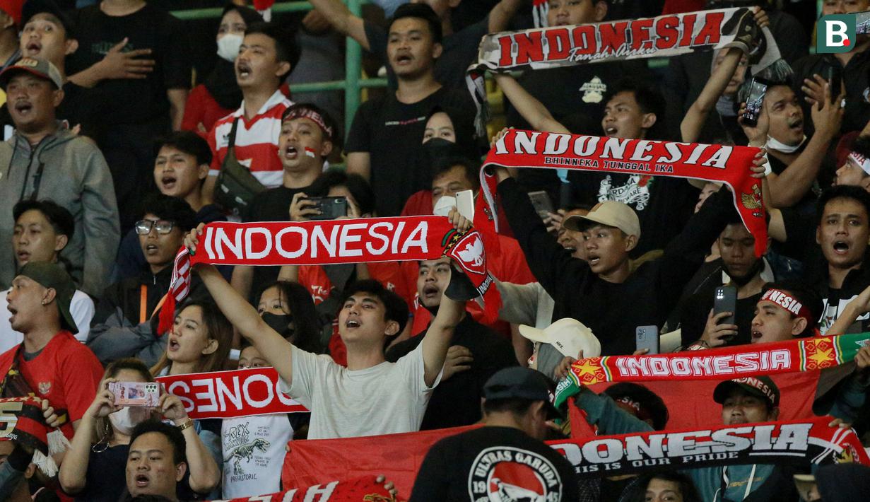 Suporter bernyanyi bersama saat memberikan dukungan kepada Timnas Indonesia U-19 yang bertanding melawan Myanmar pada laga Piala AFF U-19 2022 di Stadion Patriot Candrabhaga, Bekasi, Minggu (10/7/2022). (Bola.com/M Iqbal Ichsan)