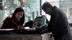 Mengenakan jaket hitam, Anggito Abimanyu tampak membawa masuk helm yang dibawanya ke dalam lobi KPK, Jakarta, (7/9/14). (Liputan6.com/Miftahul Hayat)