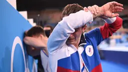 Atlet Komite Olahraga Rusia, Denis Abliazin mengusap air mata usai memenangkan final beregu putra senam artistik Olimpiade Tokyo 2020 di Ariake Gymnastics Center di Tokyo, Senin (26/7/2021). (Foto: AFP/Martin Bureau)