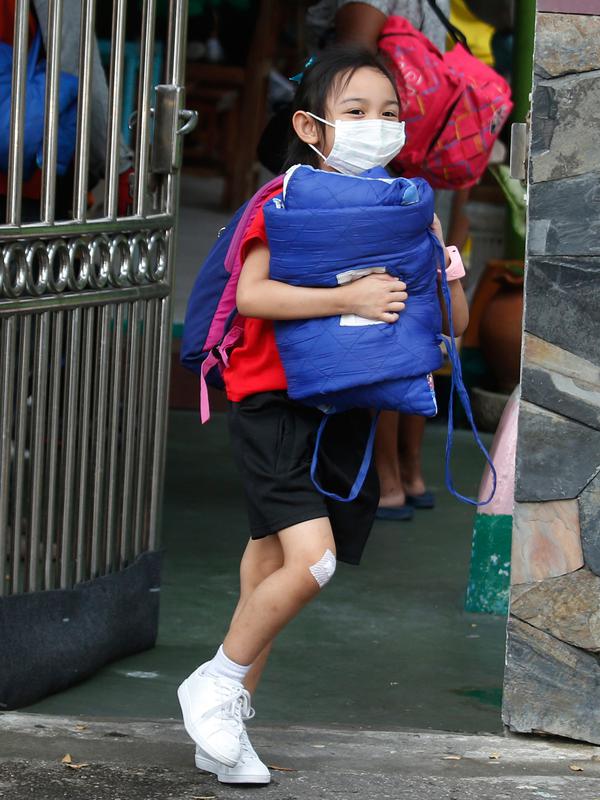 Seorang anak perempuan mengenakan masker meninggalkan sekolah saat polusi udara tingkat tinggi di Bangkok, Thailand (30/1). Polusi buruk dinilai tak sehat untuk seluruh masyarakat, khususnya anak-anak. (AP Photo/Sakchai Lalit)