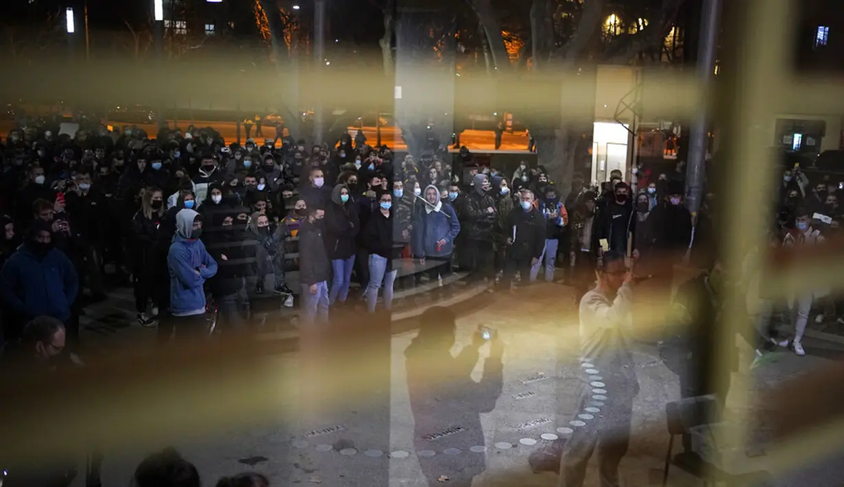 Rapper Pablo Hasel (32) terefleksi pada cermin (kanan bawah) saat berpidato di depan mahasiswa yang berkumpul di luar Universitas Lleida, Spanyol, Senin (15/2/2021). Kasus Pablo Hasel telah menyebabkan keributan di seluruh Spanyol. (AP Photo/Joan Mateu)