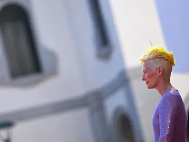 Tilda Swinton tiba menghadiri pemutaran film "The Eternal Daughter" selama Venice Film Festival 2022 ke-79 di di Lido di Venesia, Italia (6/9/2022). Aktris Inggris ini tampil memulai debutnya dengan rambut kuning neon untuk menghormati bendera Ukraina di acara tersebut. (AFP/Tiziana Fabi)