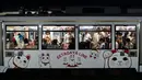 Gambar pada 25 Juni 2019, penumpang menaiki kereta Setagaya Line bergambar kucing putih dengan tangan melambai-lambai yang disebut maneki-neko di dekat Kuil Gotokuji, Tokyo. Setiap hari, kuil Gotokuji ramai dikunjungi turis yang meminta keberkahan dan kemujuran dalam hidupnya. (AP/Jae C. Hong)