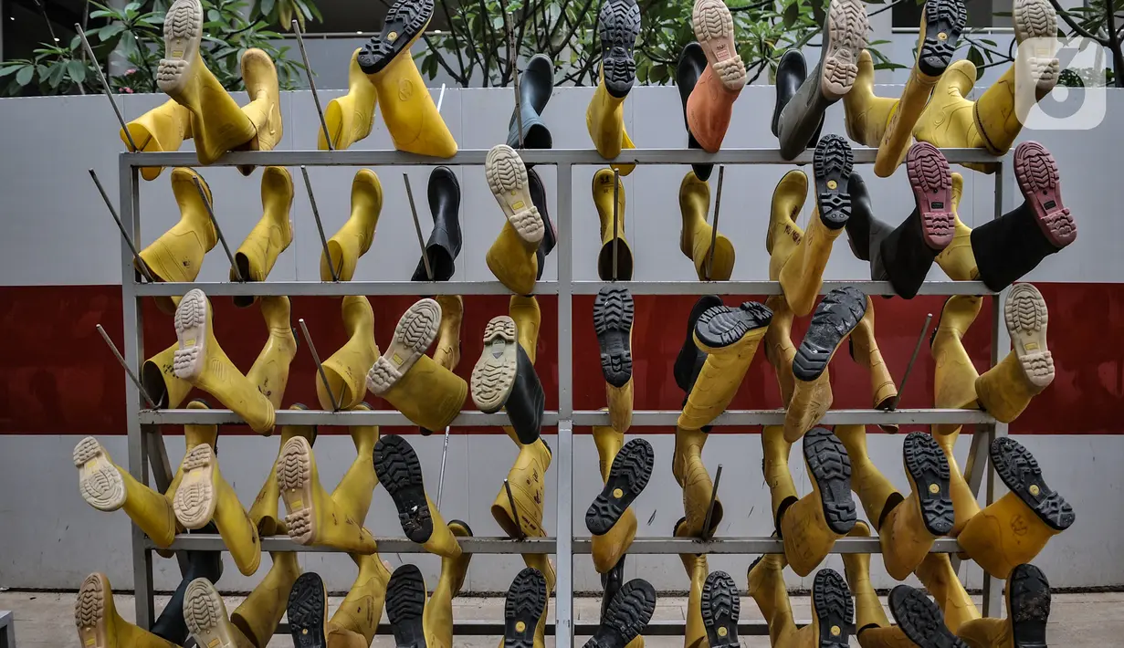 Sepatu tenaga kesehatan saat dijemur di Rumah Sakit Darurat (RSD) Wisma Atlet Kemayoran, Jakarta. Dalam sehari Tim Sterilisasi mampu mencuci hingga 300 pasang sepatu yang telah digunakan tenaga kesehatan yang bertugas menangani pasien Covid-19. (merdeka.com/Iqbal Nugroho)