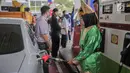 Petugas SPBU mengenakan pakaian adat mengisi bahan bakar minyak (BBM) ke sebuah mobil di kawasan Kelapa Gading, Jakarta, Senin (22/4). Dalam rangka memperingati Hari Kartini pengelola SPBU mengajak Seluruh pegawai SPBU mengenakan mengenakan baju kebaya dan baju adat. (Liputan6.com/Faizal Fanani)