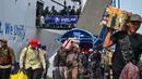 Arus mudik didominasi penumpang yang turun, kemudian melanjutkan perjalanan ke sejumlah daerah di pulau Jawa. Tampak dalam foto, para penumpang berjalan keluar untuk turun dari kapal di pelabuhan Perak, Surabaya, Jawa Timur pada Minggu 15 Maret 2026. (JUNI KRISWANTO/AFP)