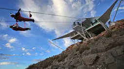 Pengunjung mencoba lintasan flying fox dari atas Gunung Jabel Jais Ras al-Khamiah di Uni Emirat Arab, 31 Januari 2018. Wisatawan dapat melihat pemandangan spektakuler, seperti pegunungan, Laut Arab juga lanskap Kota Ras Al Khaimah. (AP/Kamran Jebreili)