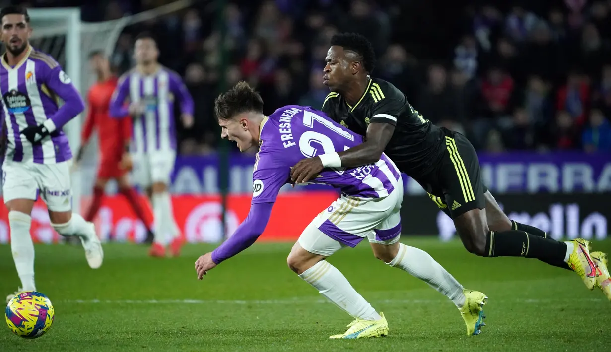 Bek Spanyol Real Valladolid Ivan Fresneda (Kiri) bersaing dengan pemain depan Real Madrid Brasil Vinicius Junior dalam duel pekan ke-15 La Liga 2022/23 di Stadion Nuevo Jose Zorrilla, Valladolid, Sabtu (31/12/2022) dini hari WIB. Real Madrid menang 2-0 berkat dua gol Karim Benzema. (CESAR MANSO / AFP)
