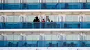 Penumpang berdiri di balkon kapal pesiar Diamond Princess yang dikarantina di Yokohama, Jepang, Jumat (21/2/2020). Dua orang Jepang dari kapal pesiar Diamond Princess dilaporkan meninggal dunia. (AP Photo/Eugene Hoshiko)