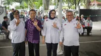 Ketua KPU Arief Budiman (kanan) bersama Komisioner KPU menunjukkan jari bertinta usai mencoblos dalam simulasi pemungutan dan penghitungan suara Pemilu 2019 di halaman Gedung KPU, Jakarta, Selasa (12/3). (Liputan6.com/Faizal Fanani)