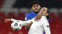 Pemain Inggris, Tyrone Mings, berebut bola dengan pemain Denmark, Yussuf Poulsen, pada laga UEFA Nations League di Stadion Wembley, Kamis (15/10/2020). Denmark menang dengan skor 1-0. (Daniel Leal-Olivas/Pool via AP)