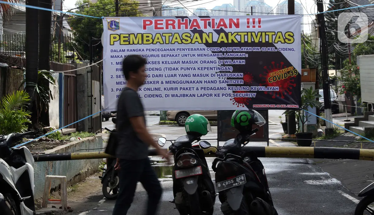 Spanduk tentang pembatasan aktivitas terpampang di pintu masuk perumahan di kawasan Cideng, Jakarta, Kamis (2/4/2020). Pemerintah menetapkan Pembatasan Sosial Berskala Besar dengan membatasi kegiatan tertentu penduduk di wilayah yang diduga terinfeksi COVID-19. (Liputan6.com/Helmi Fithriansyah)