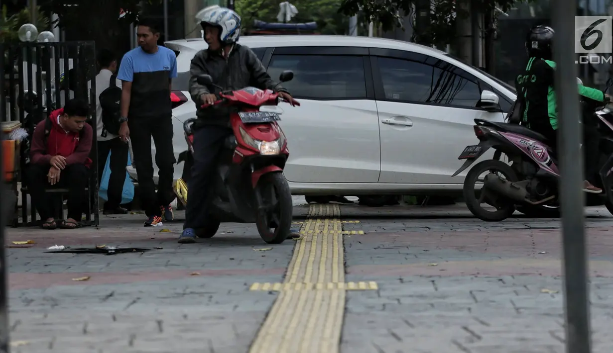 Sebuah mobil menghalangi jalur difabel trotoar di kawasan Sarinah, Jakarta, Rabu (6/1). Kondisi trotoar yang tidak steril ini menyulitkan pejalan kaki, terutama difabel saat melintas. (Liputan6.com/Faizal Fanani)