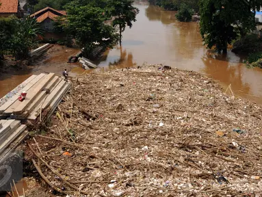 Puluhan ton sampah menumpuk di kolong jembatan Rawajati, Kalibata, Jakarta, Senin (16/11/2015). Sampah yang didominasi batang bambu terbawa arus sungai Ciliwung akibat hujan deras yang melanda Bogor pada Minggu (15/11). (Liputan6.com/Helmi Fithriansyah)