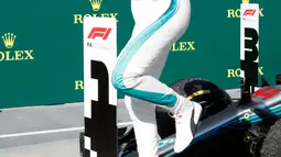 Lewis Hamilton melompat dari mobilnya merayakan kemenagan menjuarai GP Hungaria di Sirkuit Hungaroring, Mogyorod, (29/7). Kemenangan ini sekaligus menempatkan Hamilton berada di puncak klasemen. (AP Photo/Laszlo Balogh)