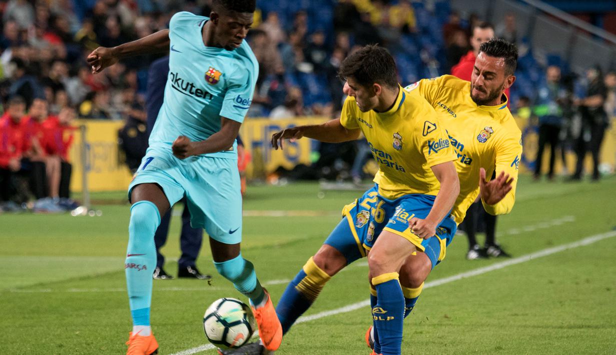 Gelandang Barcelona, Ousmane Dembele, berebut bola dengan bek Las Palmas, Aythami Artiles, pada laga La Liga Spanyol di Stadion Gran Canaria, Las Palmas, Kamis (1/3/2018). Kedua klub bermain imbang 1-1. (AFP/Desiree Martin)