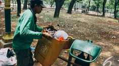 Seorang petugas sedang mengangkut sampah di kawasan Monas, Jakarta, Senin (27/10/2014). (Liputan6.com/Faizal Fanani)