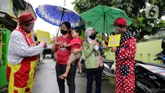 Dua badut menjemput dan mengantar warga untuk mengikuti vaksinasi COVID-19 di Pinang, Tangerang, Banten, Selasa (14/9/2021). Aksi yang dilakukan Taman Baca Badut Syariah itu dilakukan untuk mengajak warga mengikuti vaksinasi COVID-19 guna meningkatkan herd imunity. (Liputan6.com/Angga Yuniar)