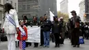 Seorang gadis berdiri dengan veteran militer AS dalam parade perayaan Hari Veteran di New York, Amerika Serikat, Rabu (11/11). Hari Veteran adalah hari libur nasional untuk menghormati jasa para tentara Amerika. (REUTERS/Shannon Stapleton)