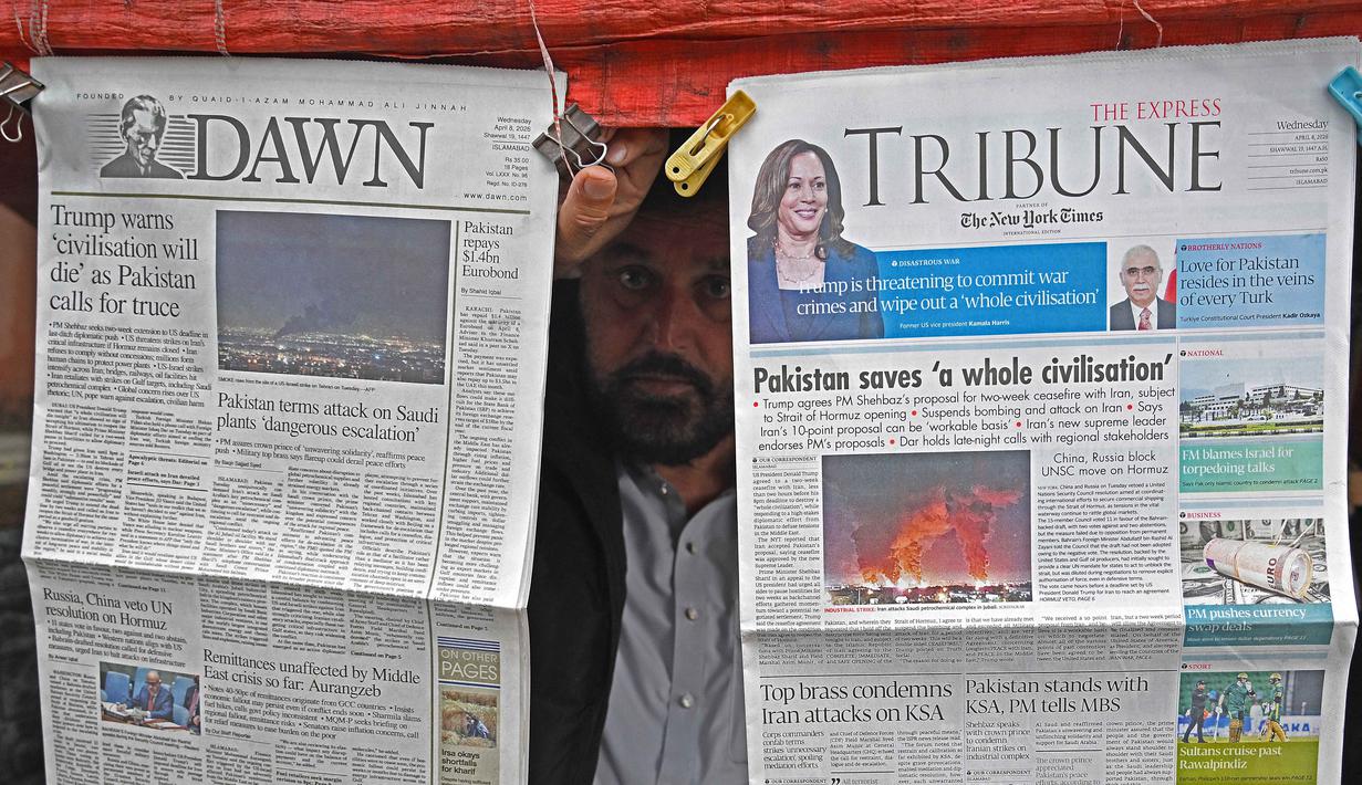 Kesepakatan, yang difasilitasi Pakistan, terjadi setelah Presiden AS, Donald Trump setuju menunda serangan selama dua minggu, dengan syarat Iran membuka kembali Selat Hormuz secara aman. Tampak dalam foto, seorang pedagang memajang koran pagi di kios pinggir jalannya di Islamabad, Pakistan, pada Rabu 8 April 2026. (Aamir QURESHI/AFP)
