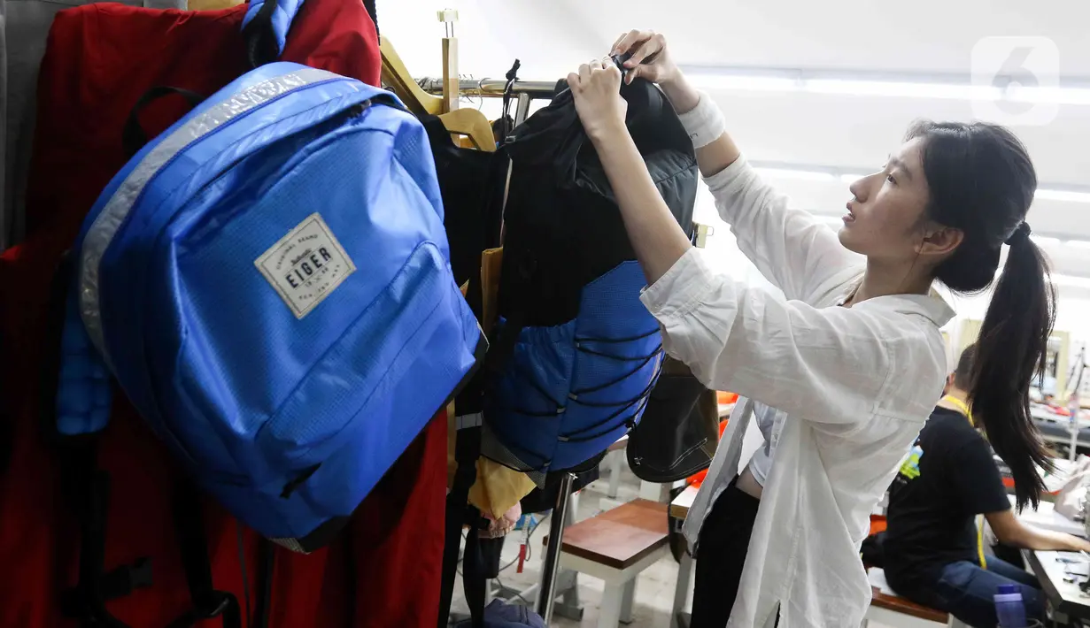 Pekerja menata produk luar ruangan atau outdoor dari barang daur naik atau up cycle di Innovation Lab Eiger. Eiger memproduksi barang dari bahan yang cacat produksi, bekas pakai, spanduk, dan lain-lain, atau yang biasa disebut dengan up-cycling. (Liputan6.com/Herman Zakharia)