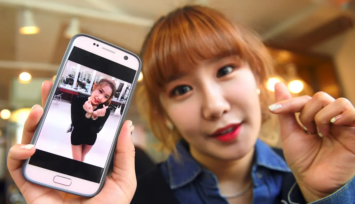 Personel girlband Six Bomb, Jung Hye-Yoon atau Ga-Bin, memperlihatkan foto dirinya sebelum menjalani operasi plastik di sebuah salon kecantikan di Seoul, Korsel, 16 Maret 2017. Da-In menjalani operasi plastik pada bagian atas tubuhnya. (YELIM LEE/AFP)