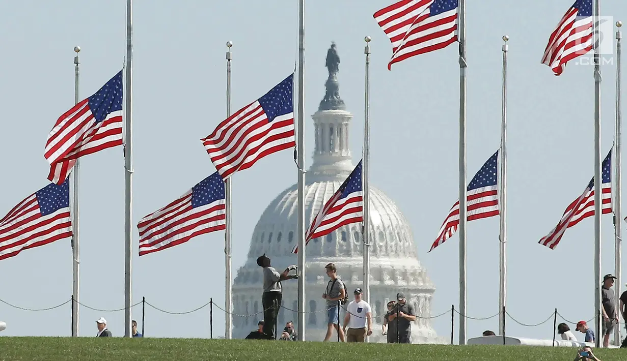 Pemandangan bendera setengah tiang di belakang gedung Capitol di Washington, DC. AS (2/10). Presiden Donald Trump memerintahkan untuk menurunkan bendera setengah tiang menyusul penembakan di Las Vegas. (Mark Wilson/Getty Images/AFP)