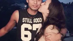 Michelle mendaratkan ciuman mesra di pipi Tontowi yang terlihat macho dengan singlet hitam. (Instagram/ michelle_ahmad)
