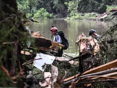 Anggota tim pencari dan penyelamat mencari orang-orang di dekat Camp Mystic, tempat di mana sedikitnya 20 anak perempuan hilang setelah banjir bandang di Hunt, Texas, Amerika Serikat pada 5 Juli 2025. (RONALDO SCHEMIDT/AFP)
