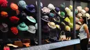 Acara yang akan menampilkan ratusan busana dan aksesori ikonik, menjadikannya sebagai pameran mode terbesar sang Ratu. Tampak dalam foto, seorang anggota staf Royal Collection Trust melihat ke arah topi, tas, dan sepatu yang dikenakan oleh Putri Elizabeth, yang dipamerkan di pameran 'Queen Elizabeth II: Her Life in Style', di The King's Gallery, Istana Buckingham, London, Inggris, Kamis 9 April 2026. (AP Photo/Kirsty Wigglesworth)