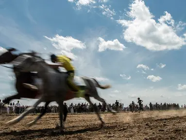 Peserta memacu kudanya saat mendekati garis finish selama festival kuda Arab di Karhuk, Hassakeh, Suriah (5/5/2019). Festival kuda Arab tahunan ini sudah berlangsung keenam kalinya di daerah Al-Jwadea. (AP Photo/Baderkhan Ahmad)