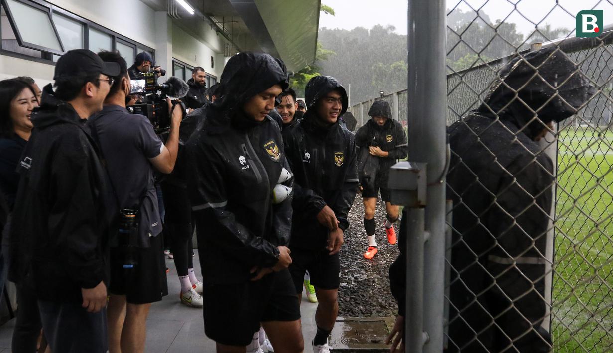 Pemain Timnas Indonesia berlari menembus hujan setelah pelatih Shin Tae-yong membatalkan latihan menjelang laga leg pertama semifinal Piala AFF 2022 menghadapi Vietnam di Lapangan A, Kompleks Gelora Bung Karno, Jakarta, Rabu (04/01/2023). (Bola.com/Bagaskara Lazuardi)