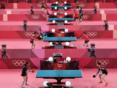 Para pemain tenis meja melakukan sesi latihan jelang Olimpiade Tokyo 2020 di Tokyo Metropolitan Gymnasium, Tokyo, Jepang, Rabu (21/7/2021). Olimpiade Tokyo 2020 akan dibuka pada 23 Juli 2021. (Jung Yeon-je/AFP)