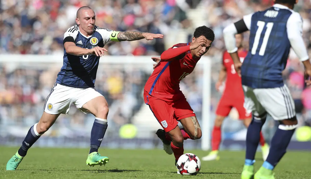 Gelandang Inggris, Dele Alli, berusaha melewati beberapa pemain Skotlandia pada kualifikasi Piala Dunia 2018 di Hampden Park, Sabtu (10/6/2017). Skor berakhir imbang 2-2. (AP/Scott Heppell)