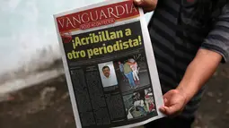 Seorang pria menunjukkan koran yang berisi berita tewasnya wartawan Leobardo Vazquez di Gutierrez Zamora, Meksiko (22/3). Vazquez adalah wartawan ketiga yang dibunuh di Meksiko tahun ini. (AP/Felix Marquez)