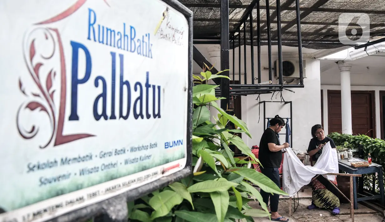 Pengajar yang merupakan penyandang tunarungu mengajarkan anak-anak cara membatik di Rumah Batik Palbatu, Jakarta, Minggu (2/10/2022). Dalam rangka memeriahkan Hari Batik Nasional, Rumah Batik Palbatu menggelar pelatihan membatik kepada masyarakat umum sebagai upaya meningkatkan minat terutama bagi generasi milenial dalam melestarikan seni kriya tersebut. (merdeka.com/Iqbal S. Nugroho)