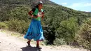 Wanita suku Raramuri dari ras Tarahumara mengikuti lomba lari maraton Ultra Trail Cerro Rojo di negara bagian Chihuahua, Meksiko, Sabtu (15/7). Dalam lomba marathon itu, suku Tarahumara hanya memakai sandal dari karet daur ulang. (Herika MARTINEZ/AFP)
