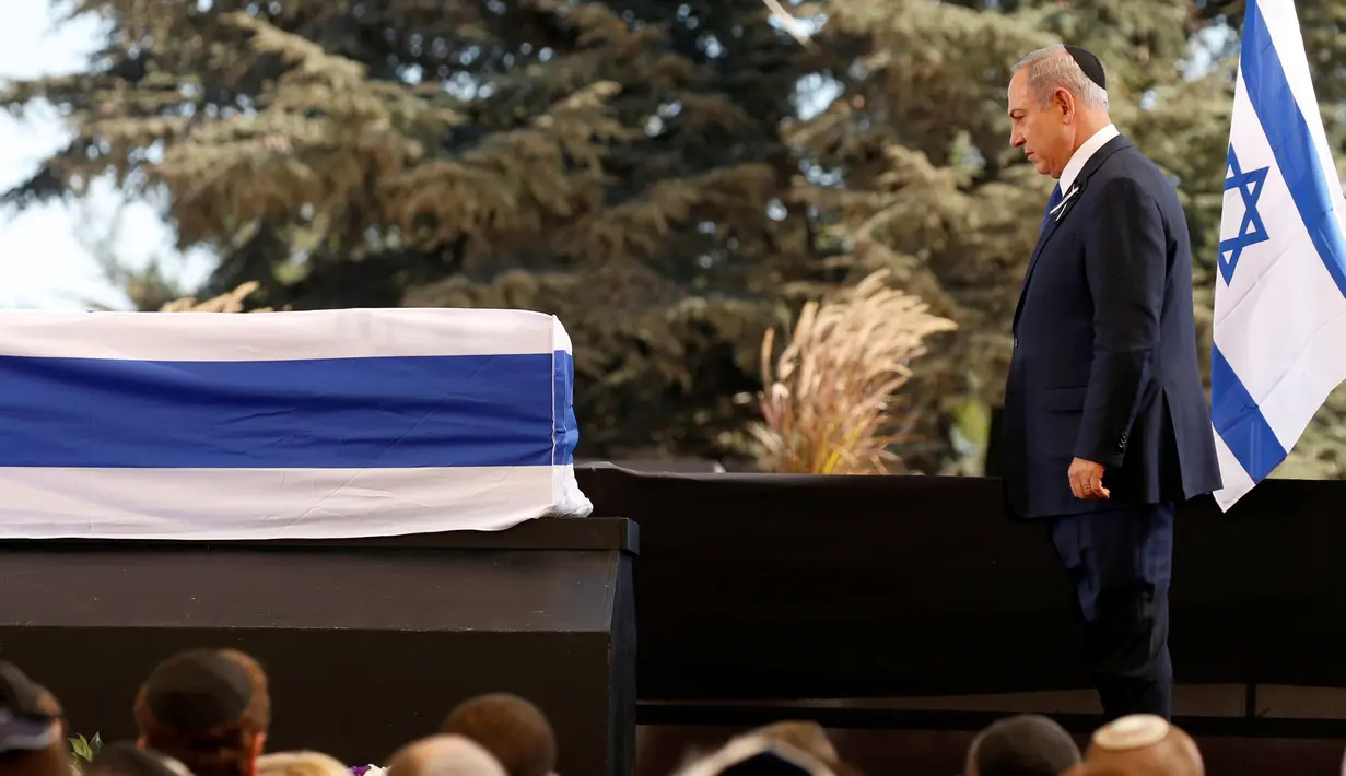 Perdana Menteri Israel Benjamin Netanyahu berdiri di depan peti jenazah mantan Presiden Israel Shimon Peres, saat upacara pemakaman di Gunung Herzl, Yerusalem, Jumat (30/9). Peres meninggal dunia karena terkena serangan stroke. (REUTERS/ KEVIN LAMARQUE)