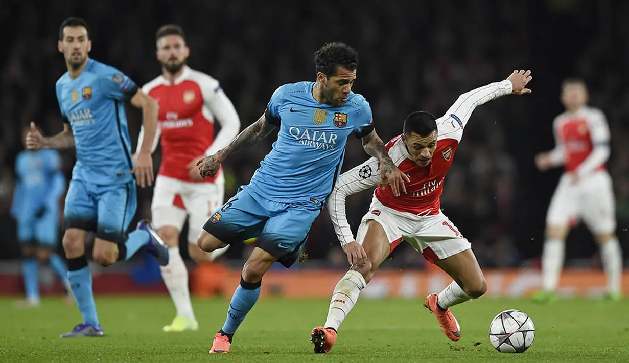 Penyerang Arsenal, Alexis Sanchez, berebut bola dengan bek sayap Barcelona, Dani Alves. Meski bermain tandang, namun Barcelona lebih menguasai jalannya laga. (Reuters/Toby Melville)